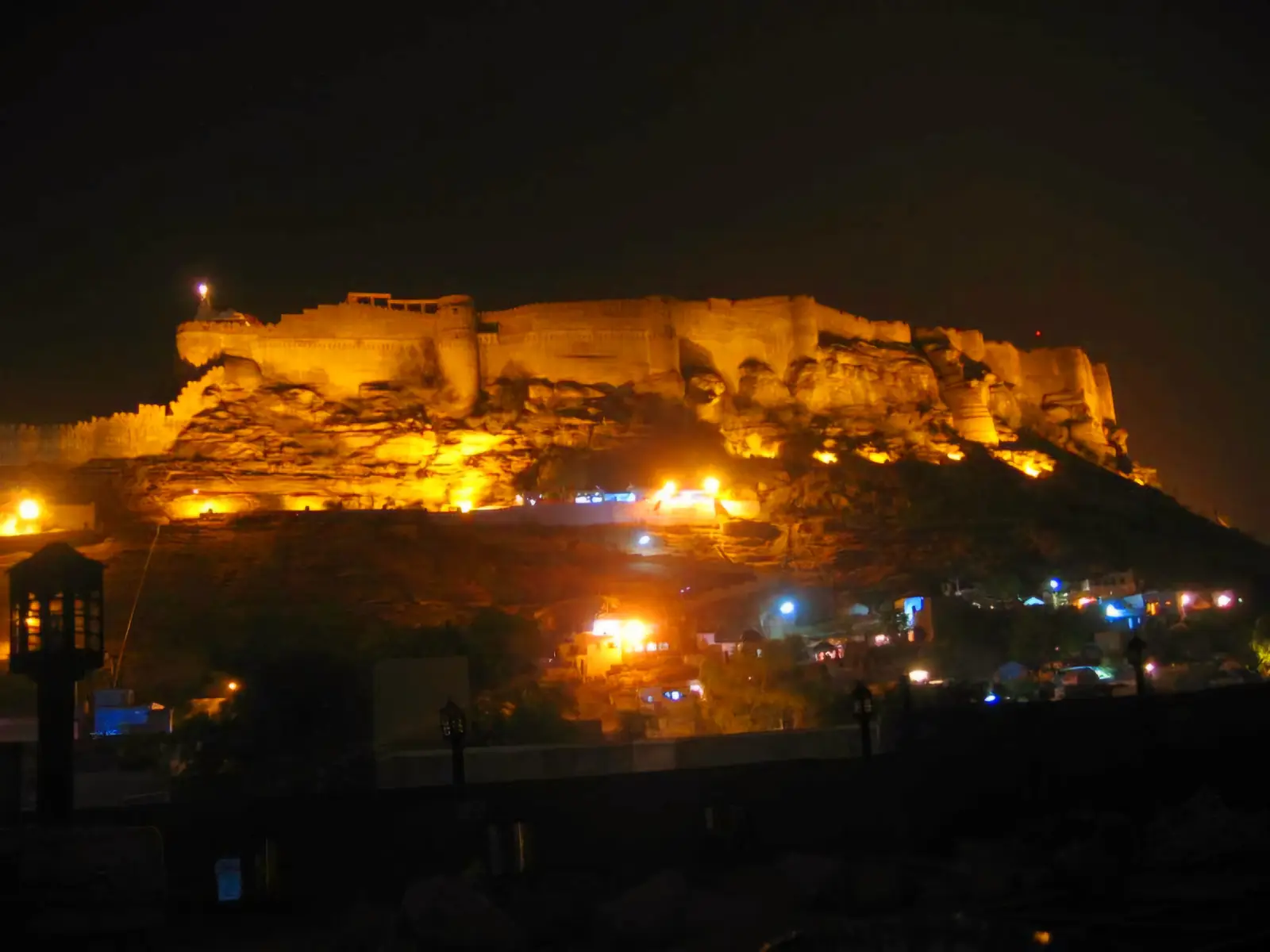 Mehrangarh Fort lit up at night above the blue houses of Jodhpur