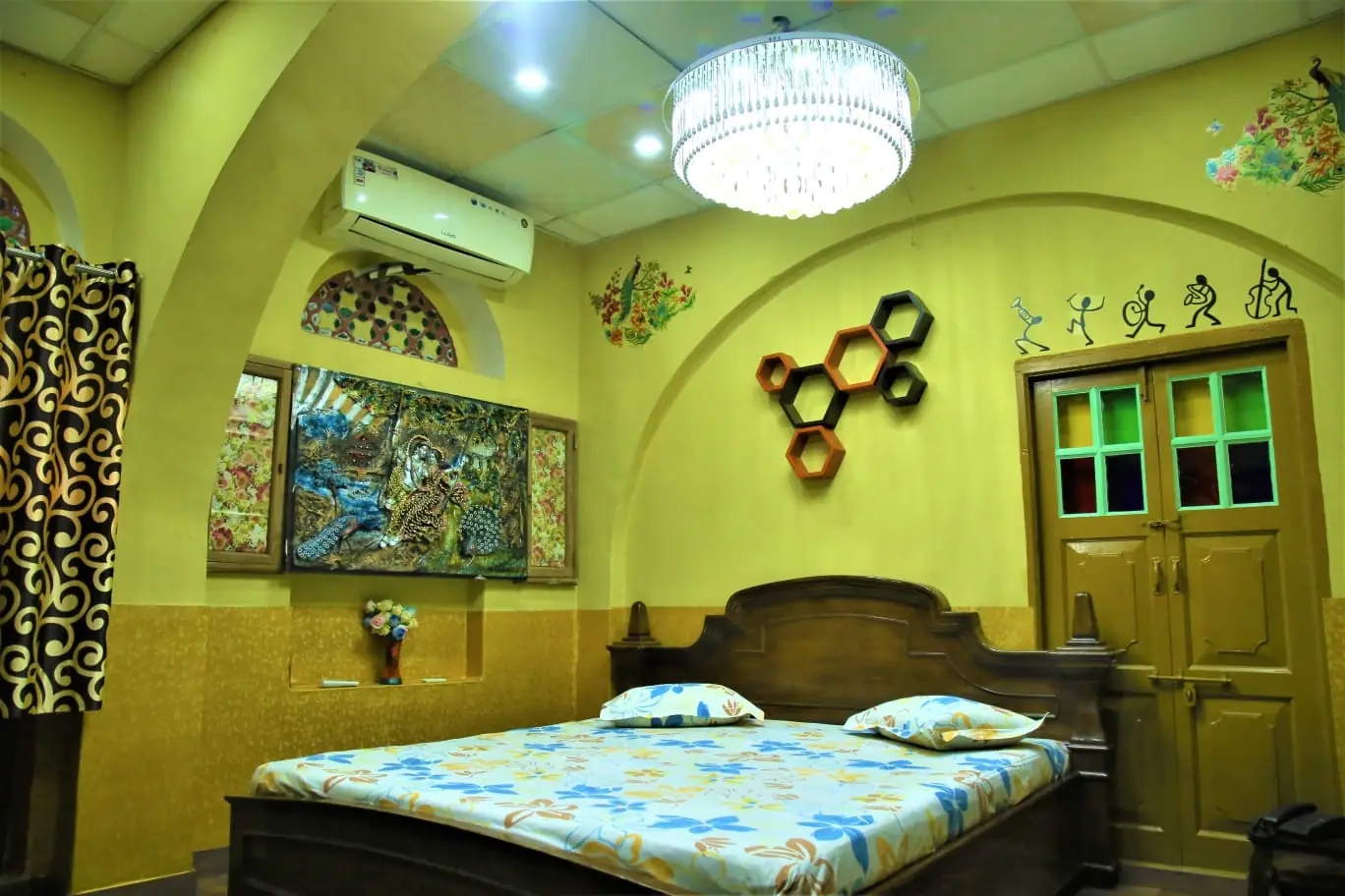 Grand Family Room at Saji Sanwri Heritage Inn Haveli with king size bed, crystal chandelier, hexagonal wall shelves and hand painted Rajasthani murals