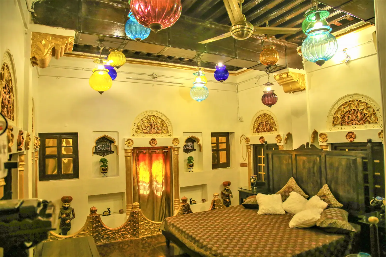 Heritage Super Deluxe Room at Saji Sanwri Heritage Inn Haveli with ornately carved wooden bed and teakwood ceiling